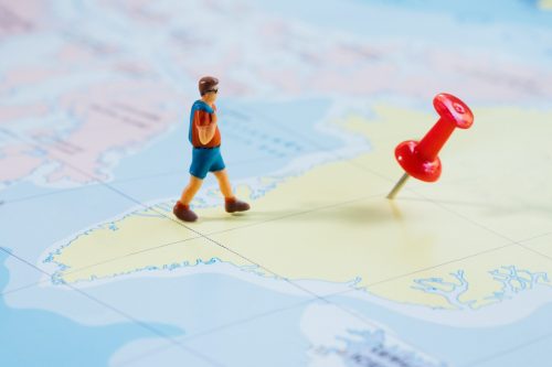 mini-figure-traveler-with-red-pushpin-map-travel-concept-min